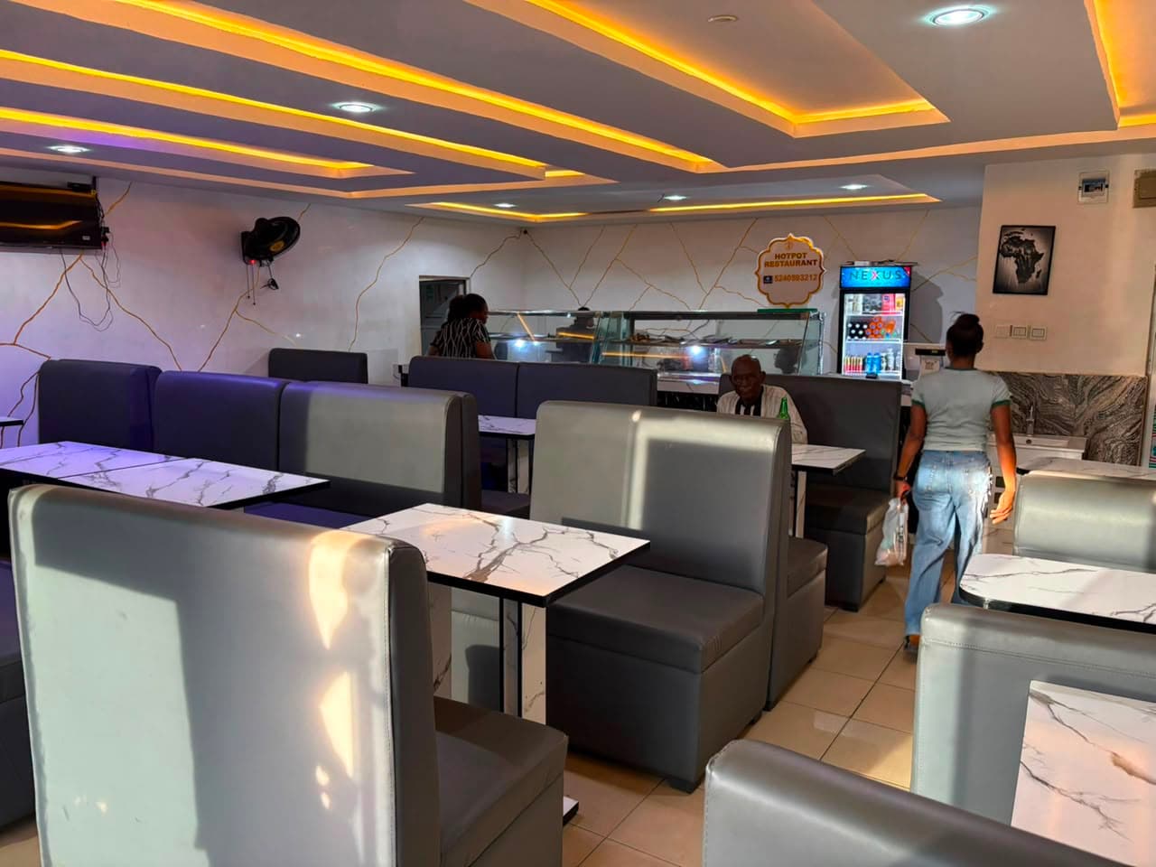 The air-conditioned dining room with grey booth seating and marble-topped tables